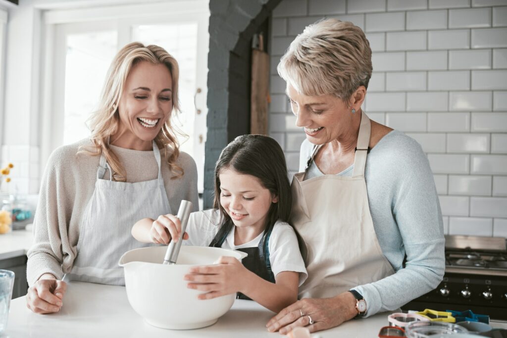 Family, children and baking with a mother, grandmother and girl in the kitchen of their home